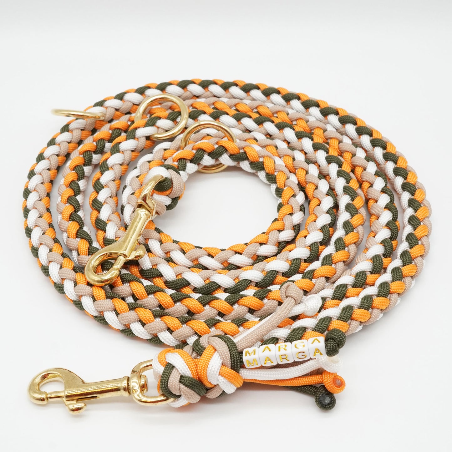 Detailaufnahme einer eleganten Hundeleine aus Paracord in den Farben Orange, Grün und Mocca. Perfekt für Tierliebhaber, die ihren Hunden nur das Beste bieten möchten.