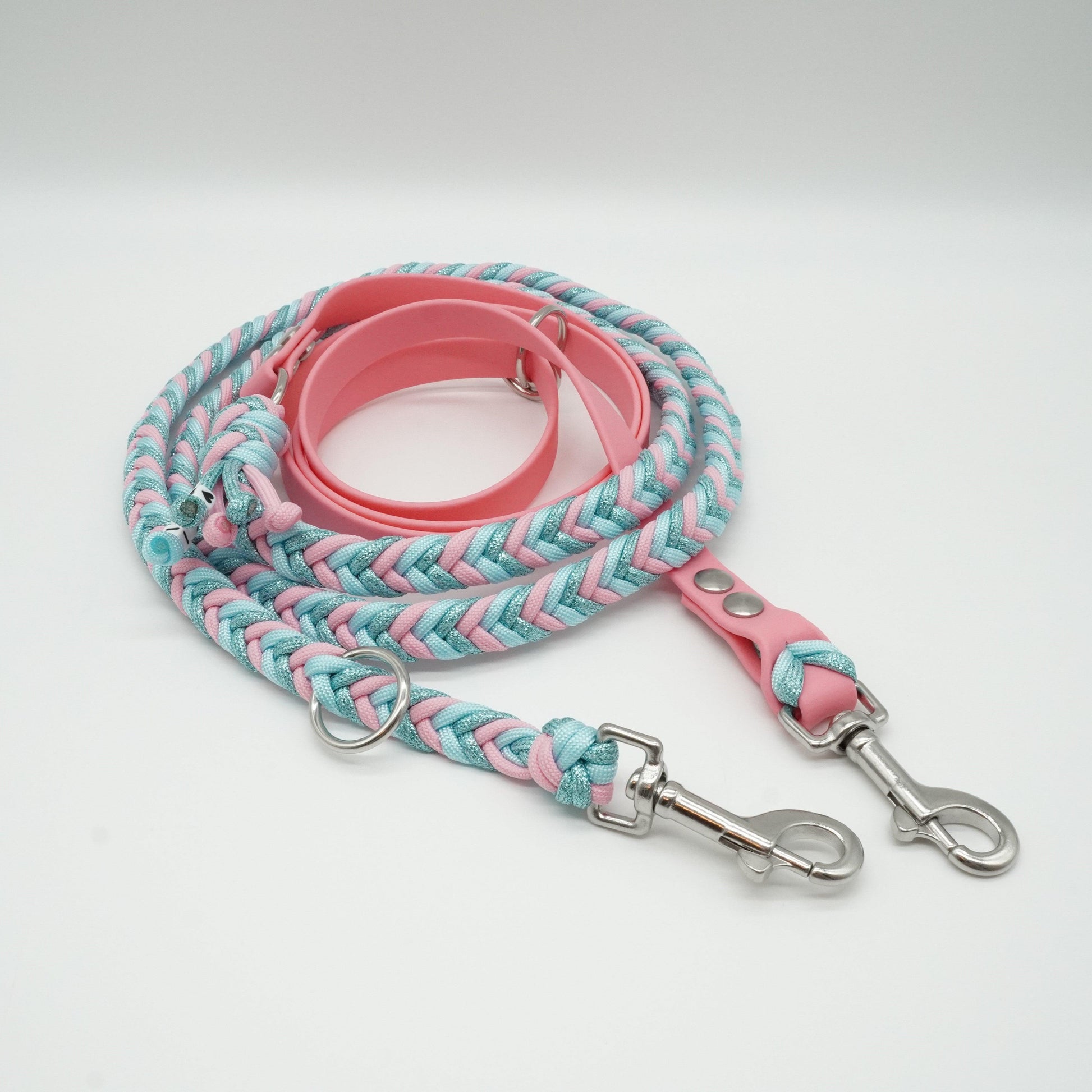 Handgefertigte verstellbare Hundeleine aus rosafarbener Biothane und geflochtenem Paracord in Rosa, Türkis und Hellblau mit silbernen Karabinern.