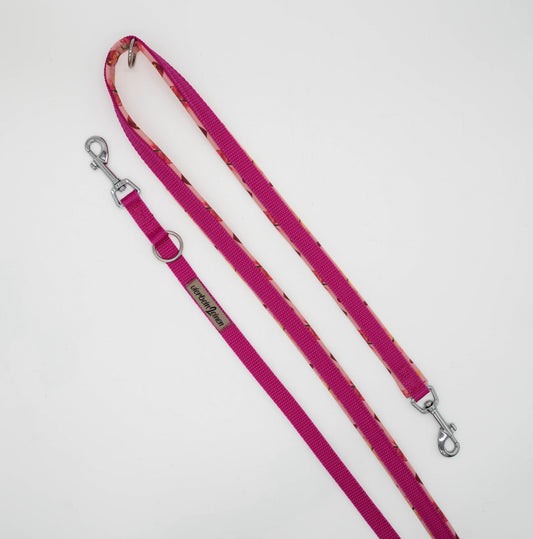 Handgefertigte verstellbare Hundeleine aus pinkem Gurtband mit floralem Stoffdesign und silbernen Karabinern.