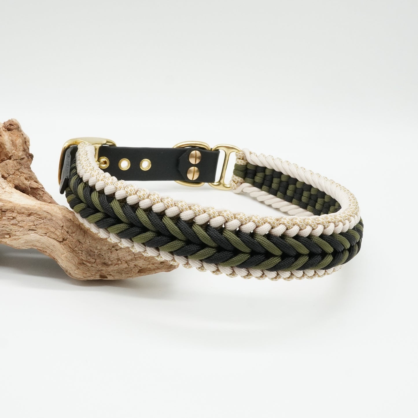 Handgefertigtes Hundehalsband aus schwarzer Biothane und geflochtenem Paracord in Schwarz, Olivgrün, Weiß und Gold mit goldfarbenen Beschlägen.