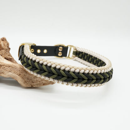 Handgefertigtes Hundehalsband aus schwarzer Biothane und geflochtenem Paracord in Schwarz, Olivgrün, Weiß und Gold mit goldfarbenen Beschlägen.