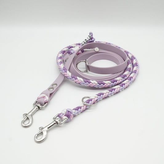 Handgefertigte verstellbare Hundeleine aus fliederfarbener Biothane und geflochtenem Paracord in Flieder, Rosa und Weiß mit silbernen Karabinern.