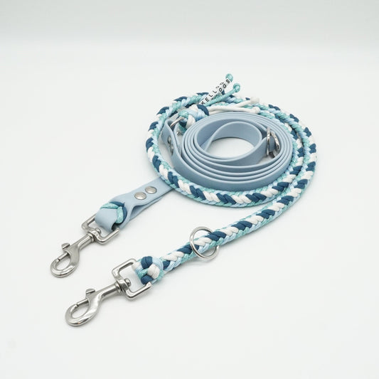 Handgefertigte verstellbare Hundeleine aus hellblauer Biothane und geflochtenem Paracord in Hellblau, Petrol und Weiß mit silbernen Karabinern.